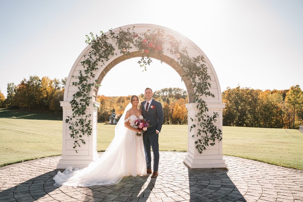 a man and woman posing for a picture under a archway